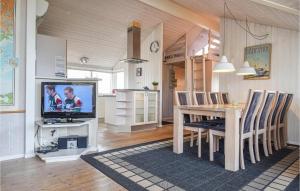 a living room with a dining table and a tv at Holiday Home Klægdalen Ringkøbing Denm in Halkær