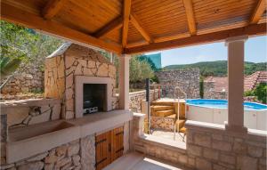 an outdoor kitchen with a fireplace and a hot tub at One-Bedroom Holiday Home In Nerezisca in Nerežišća