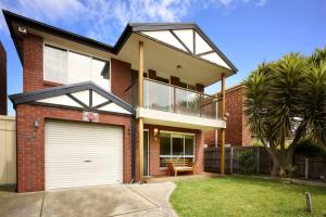 una casa de ladrillo rojo con garaje blanco en Your Home Retreat in Maribyrnong, en Melbourne