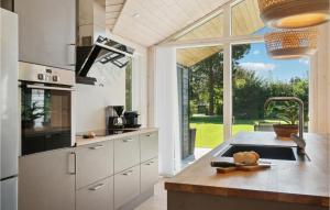 a kitchen with white cabinets and a large window at Stunning Home In Stege With Wifi in Stege