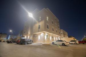 a large building with cars parked in a parking lot at شقه 7فاخره ثلاث غرف نوم وجلسه خارجيه in Riyadh