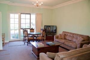 ein Wohnzimmer mit einem Sofa und einem Tisch in der Unterkunft Holly Lane Mews in Yarra Glen