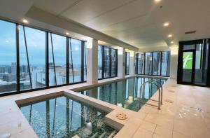 an indoor swimming pool in a building with windows at Downtown Delight Experience Melbourne in Style in Melbourne