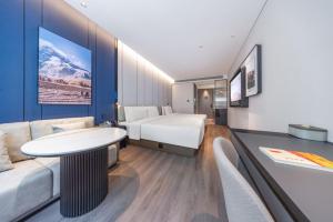 a hotel room with a bed and a couch at Atour Hotel Beijing Chaoyang High Speed Railway Station in Beijing