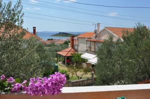 een uitzicht op een huis met paarse bloemen bij Apartments Petar Maksan in Pakoštane