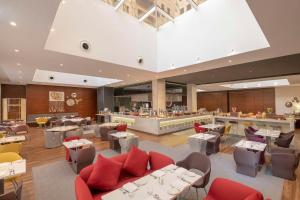a restaurant with tables and chairs and a bar at Hyatt Place Dubai Wasl District in Dubai
