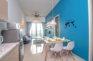 a kitchen with a blue wall and a table and chairs at DPULZE Residence By IdealHub in Cyberjaya