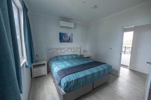 a bedroom with a bed and a large window at Ningaloo Coral Bay – Bayview in Coral Bay +33 photos