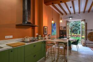a kitchen with green cabinets and a table with chairs at Casa Carmen Murcia in Murcia +9 photos