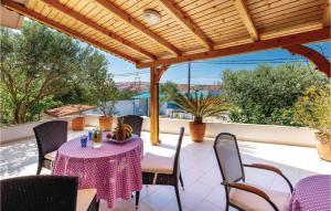 a patio with a table and chairs under a wooden pergola at Nice Home In Barbat With House Sea View in Barbat na Rabu