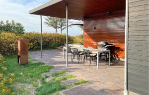 a patio with a table and chairs and a grill at Four-Bedroom Holiday Home In Lundby in Lundby +20 photos