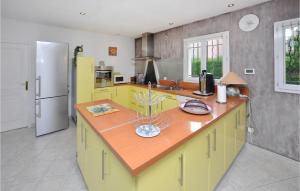 a kitchen with yellow cabinets and a counter top at Nice Home In Saint-Cézaire-Sur-Siagne in Saint-Cézaire-sur-Siagne