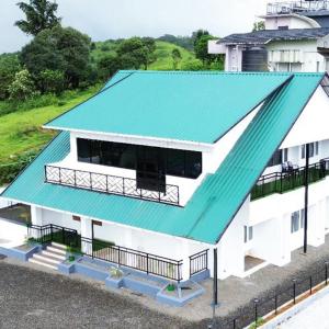 a white house with a green roof and a fence at Fairhaven Misty Hills in Vagamon +6 photos