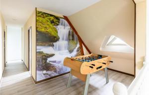 a room with a chess board in front of a waterfall painting at Gorgeous Home In Joué Les Tours in Joue-les-Tours