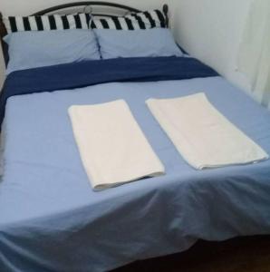 a blue bed with two white pillows on it at Bohol Staycation in Tagbilaran City in Tagbilaran City +53 photos