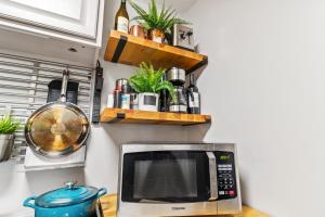 Mountain Crest 3 Studio Near Slopes And Shuttle Bus WiFi Gated Parking في سنوشو: طاولة مطبخ مع ميكروويف وبعض النباتات +صورتان