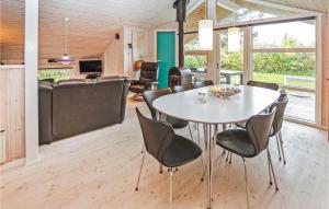 a dining room and living room with a table and chairs at Holiday Home Stentoften Xi in Hesselager