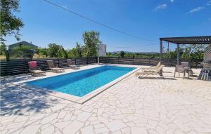 a swimming pool with chaises and chairs on a patio at 4 Bedroom Lovely Home In Miranje Gornje in Miranje Gornje