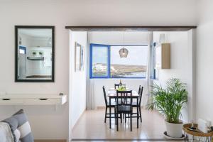 a dining room and living room with a table and chairs at Casa Costa Jameos in Punta de Mujeres