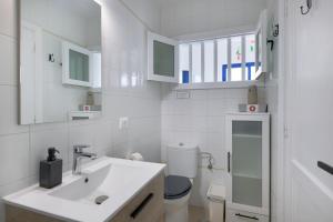 a white bathroom with a sink and a toilet at Costa Jameos Oceanfront-Lava Pools in Punta Mujeres +26 photos