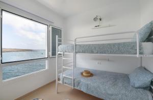 a room with two bunk beds and a window at Costa Jameos Oceanfront-Lava Pools in Punta Mujeres