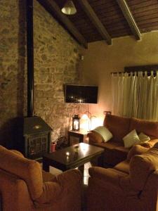un soggiorno con divano e stufa a legna. di Rural Pedroches Casa Los Mineros a Villanueva del Duque