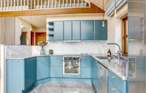 a kitchen with blue cabinets and a sink at Two-Bedroom Holiday Home In Hejls in Hejls +20 photos