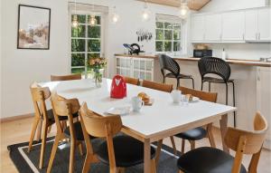 a kitchen and dining room with a white table and chairs at Cozy Home In Idestrup With Sauna in Marielyst