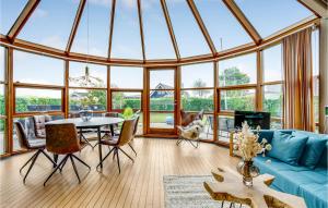 a conservatory with a blue couch and a table and chairs at Two-Bedroom Holiday Home In Hejls in Hejls