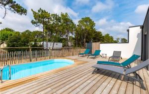 a deck with chairs and a swimming pool at Cozy Home In Stjean De Monts in Saint-Jean-de-Monts