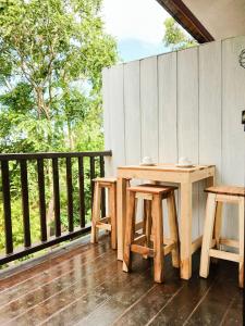 a wooden table and two chairs on a deck at Samui Wooden Hill Resort in Lamai