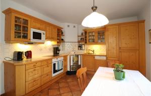uma grande cozinha com armários de madeira e uma mesa em Landhaus Mit Sauna Kleblach em Fellbach