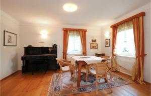 uma sala de jantar com uma mesa e um piano em Landhaus Mit Sauna Kleblach em Fellbach