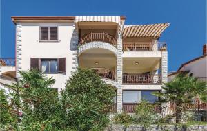 an apartment building with balconies and trees at Two-Bedroom Apartment In Rabac in Rabac