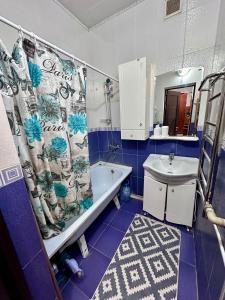 a blue and white bathroom with a shower curtain at Комфортабельная 3-х комн квартира in Qyzylorda