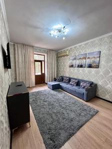 a living room with a blue couch and a rug at Комфортабельная 3-х комн квартира in Qyzylorda +7 photos