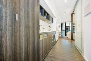 un couloir d'une maison avec des boiseries et une cuisine dans l'établissement Stylish 1 Bedroom Retreat in St Kilda w Car Park, à Melbourne