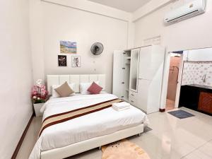 a white bedroom with a large bed and a fireplace at Pause Homestay 2 Hat Yai in Hat Yai