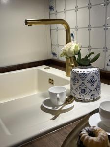 a bathroom counter with a sink and a vase with a flower at Annika1 in Tinnum +13 photos
