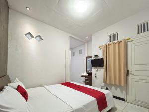 a bedroom with a bed and a television in it at RedDoorz Near Alun Alun Kota Wisata Batu in Batu