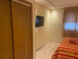 a bedroom with a bed and a flat screen tv at Panoramic view Condo Mehdia in Kenitra