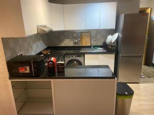 a small kitchen with a refrigerator and a washer at Panoramic view Condo Mehdia in Kenitra
