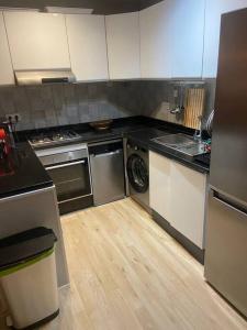 a kitchen with a stove and a washer and dryer at Panoramic view Condo Mehdia in Kenitra