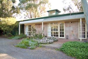 a house with white flowers in front of it at Holly Lane Mews in Yarra Glen