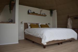 a bedroom with a large bed with white blankets and pillows at Domein de Koekoeksvlooghe in Lo-Reninge