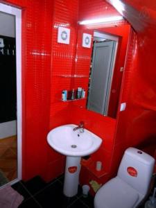 a red bathroom with a sink and a toilet at Marco Polo, Mountain View Apartment in Gudauri