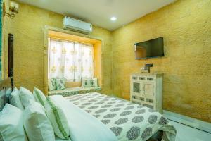 a bedroom with a large bed and a television at Bhim Kothi in Jaisalmer