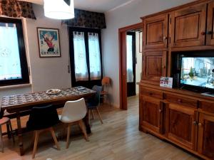 a living room with a dining table and a tv at APPARTAMENTO CHEMIN DE FER in Saint Vincent