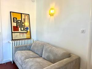 a living room with a couch and a light on the wall at Studio lumineux à 100m de la plage ! in Saint-Jean-de-Luz