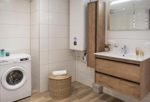 a bathroom with a washing machine and a sink at Au Fil de l'Eau - Cosy in Barr +14 photos